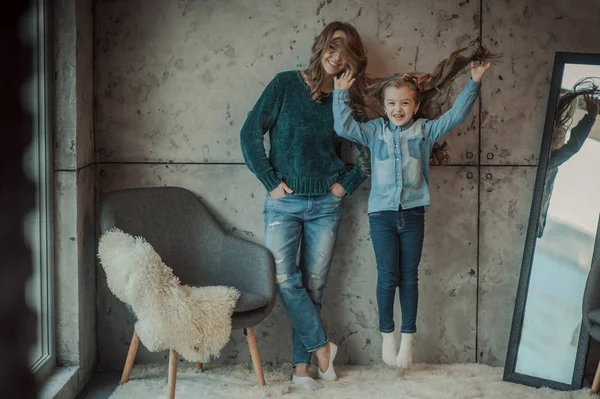 Sonriente madre con su hija en la habitación de la alfombra —  Fotos de Stock