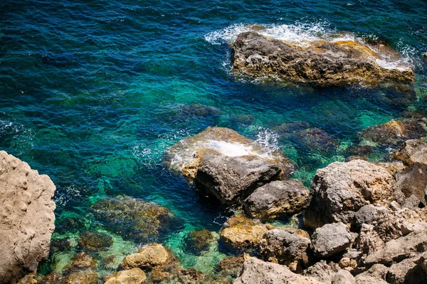 Felsen mit Höhlen und klarem türkisfarbenem Wasser — Stockfoto