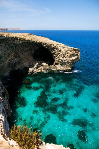 Playa rocosa y gruta con agua azul Imágenes de stock libres de derechos