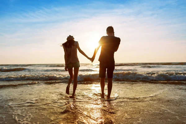 Pareja disfrutando de una velada romántica en la playa al atardecer — Foto de Stock