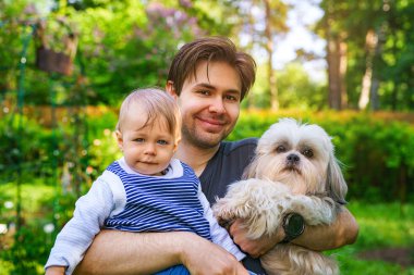 Baba ile oğlu ve köpek birlikte portre yaz yeşil bahçesinde