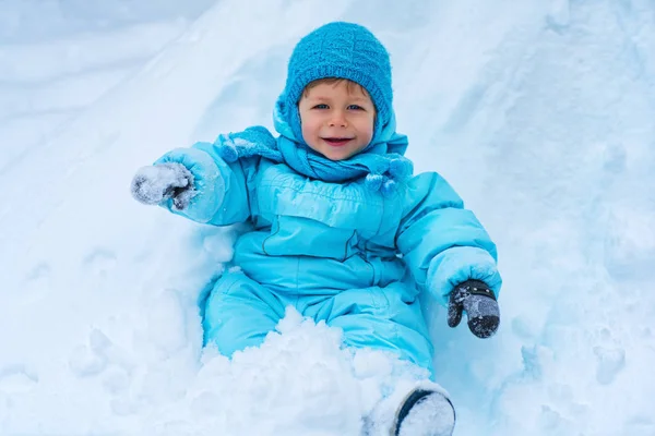 Bambino seduto sulla neve — Foto Stock