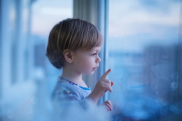 Barnet tittar på fönster — Stockfoto