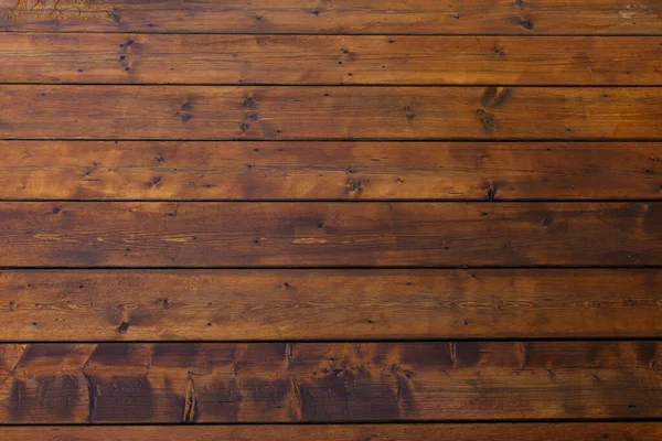 Stained wet deck wooden boards with water drops, brown planks texture