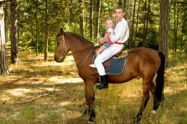 Jonge vader dochter rollen op het paard in het bos — Stockfoto