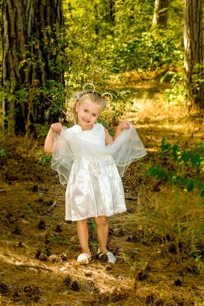 Dziewczynka w piękną sukienkę spacery w lesie — Zdjęcie stockowe