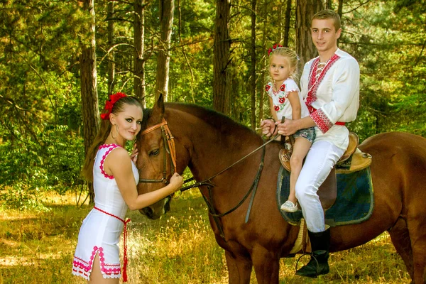 Oekraïners moeder en vader en dochter in het bos met een paard — Stockfoto