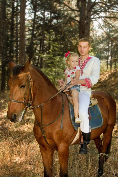 Jonge vader dochter rollen op het paard in het bos — Stockfoto