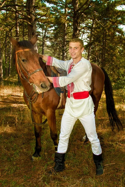 Jonge Oekraïense met een paard in het bos — Stockfoto