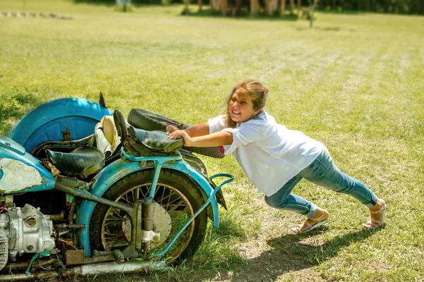 Mała dziewczynka pcha w motocyklu — Zdjęcie stockowe