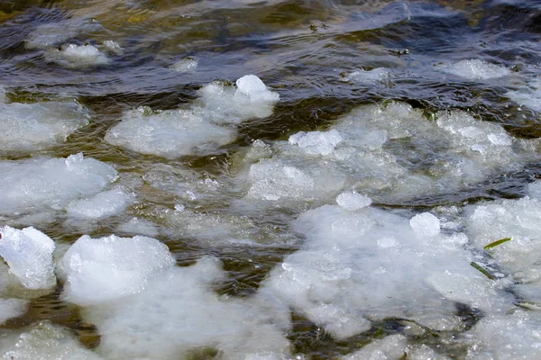 Melting snow floats along a small river — Stock Photo, Image