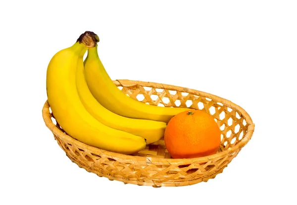 Τρεις μπανάνες και ένα πορτοκάλι στο ένα πιάτο λυγαριά — Φωτογραφία Αρχείου