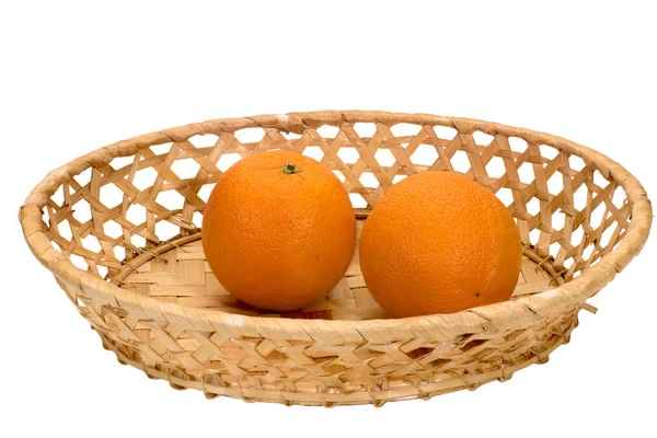 Δύο ώριμα πορτοκάλια σε ένα πιάτο λυγαριά — Φωτογραφία Αρχείου