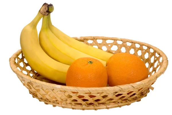 Drei reife Bananen und zwei Orangen in einem Weidenteller — Stockfoto