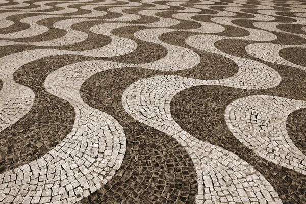 Typiska portugisiska kullerstensbelagda trottoaren. I Sepia tonad. Retro s — Stockfoto