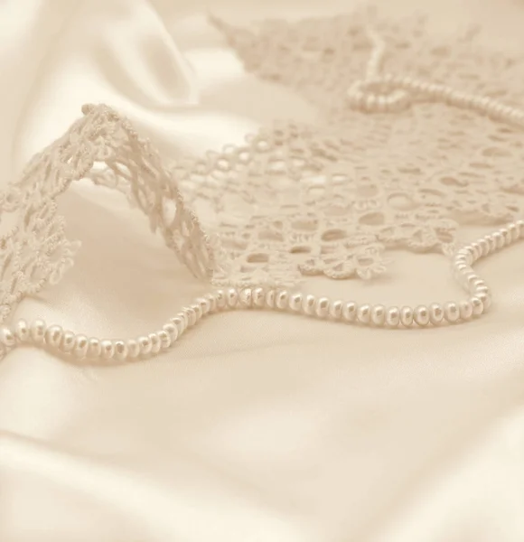 Smooth elegant golden silk or satin with pearls and lace as wedd — Stock Photo, Image