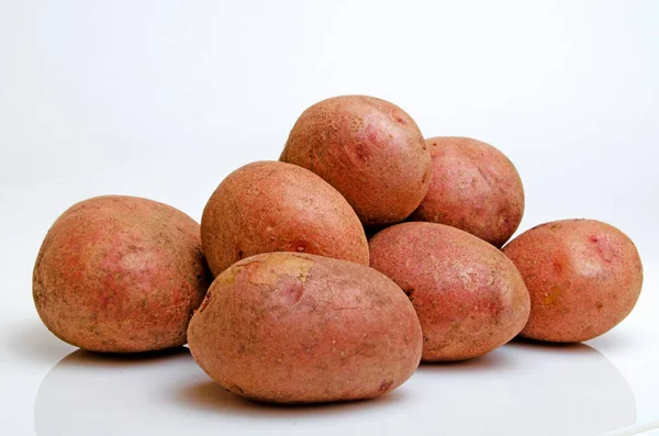 Aardappelen roze op een lichte roze achtergrond. — Stockfoto