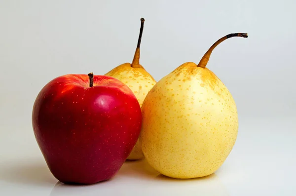 Roter Apfel und gelbe Birne. — Stockfoto