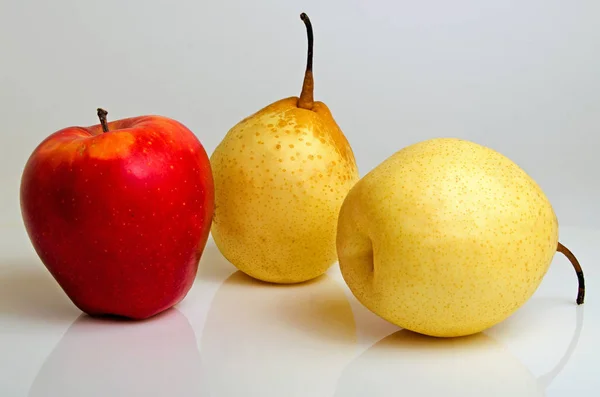 Roter Apfel und gelbe Birne. — Stockfoto