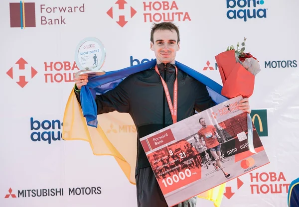 Vencedor do Prêmio Romanenko Roman (3d lugar) na corrida por uma distância de 21 km na Meia Maratona Nova Poshta Kyiv. 09 Abril 2017 Fotos De Bancos De Imagens