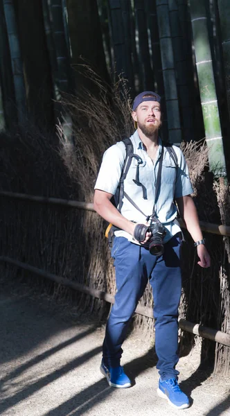 Un joven con una cámara en el bosque de bambú — Foto de Stock