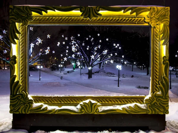 An empty art frame with illumination in the winter city park — Stock Photo, Image