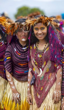 Endonezya, Papua Yeni Gine, Wamena, Irian Jaya, 20 Ağustos 2018: Papuan kabilesinden iki kadın Wamena, Papua Yeni Gine 'deki Baliem Vadisi festivalinde kuş tüylerinden güzel bir taç giydiler.