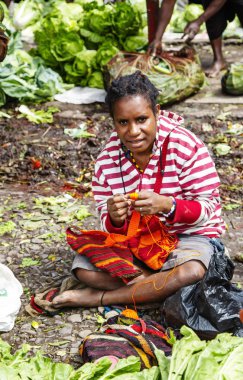 Endonezya, Papua Yeni Gine, Wamena, Irian Jaya, 20 Ağustos 2019: Papualı kadın Wamena, Papua Yeni Gine, Endonezya 'da pazarda çok renkli bir çanta örüyor