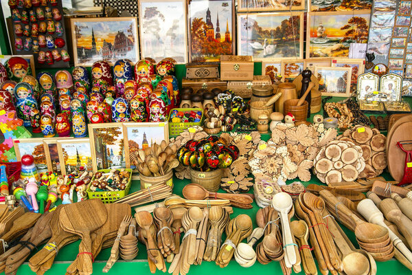 RIGA, LATVIA, MARCH, 20 2019: Street market in Old Town where variety wood products - paintings, nesting dolls and much more are sold in Riga, Latvia