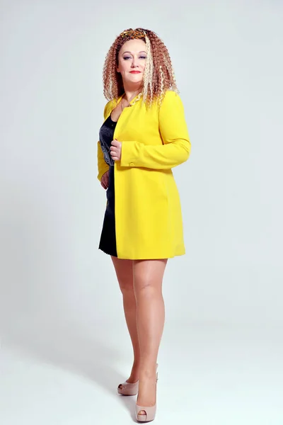 Kecses Karcsú Lány Göndör Haj Egy Sárga Kabát Pózol Stúdióban — Stock Fotó