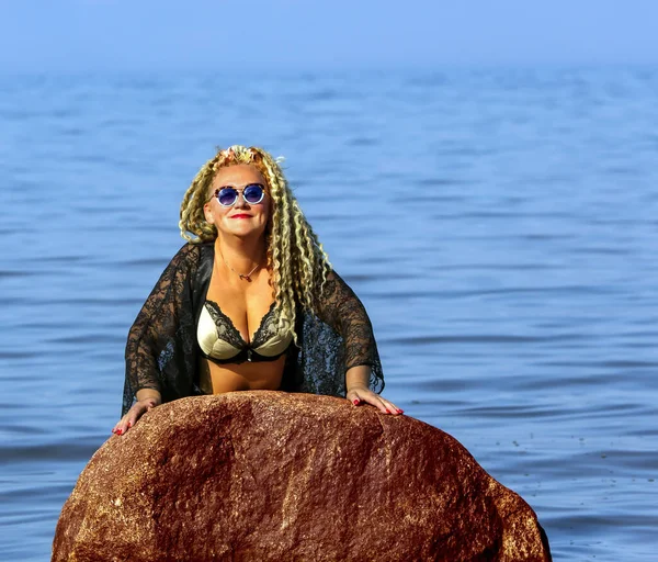 魅力的な女の子とともに巻き毛で黒PeignirとA美しいブラ上の石でバルト海 — ストック写真