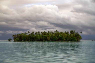 Fransız Polinezyası 'nın Toplum Adaları' ndaki Leeward grubunun mavi gölünde yağmurdan önce Güzel Cennet adası.