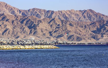 Koyu mavi Kızıldeniz ve Ürdün 'ün kıyısı yükselen Edom dağlarının gerisinde kalıyor, Eilat, İsrail