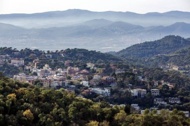 Akşam sisli küçük bir kasabadan Pireneler 'in ağaçlık tepelerinin arasından İspanya' ya bak.