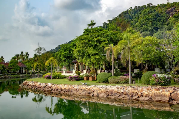 タイのトロピカル チャン島にある美しい熱帯公園に囲まれた池の岸にある夏の木造バンガロー — ストック写真