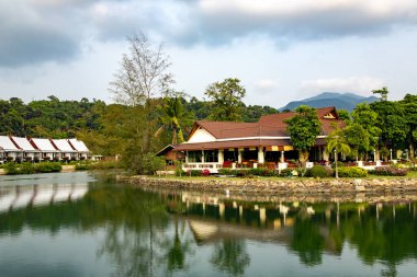 Tayland 'da tropik Koh Chang adasında güzel bir tropikal park ile çevrili göletin kıyısındaki tahta bungalovlar..