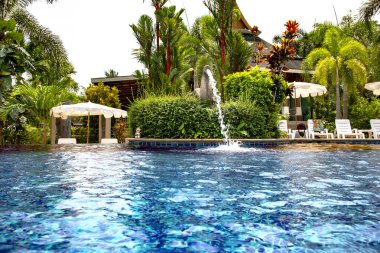 Tayland 'ın Koh Chang adasındaki tropik bahçelerin ortasında turkuaz bir suyla yüzme havuzu.