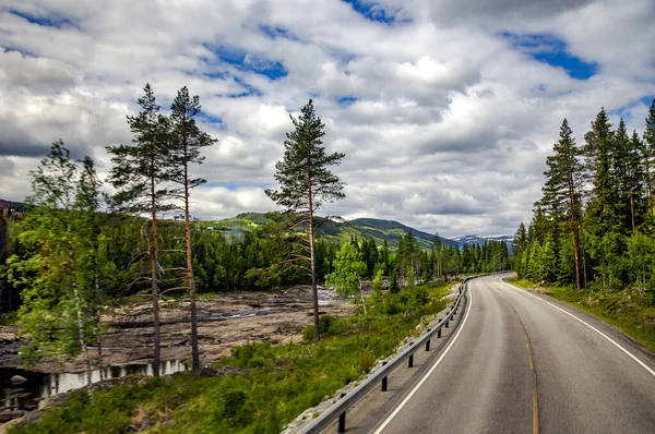 挪威风景秀丽的空旷道路被树木和秀丽的群山环绕着 — 图库照片