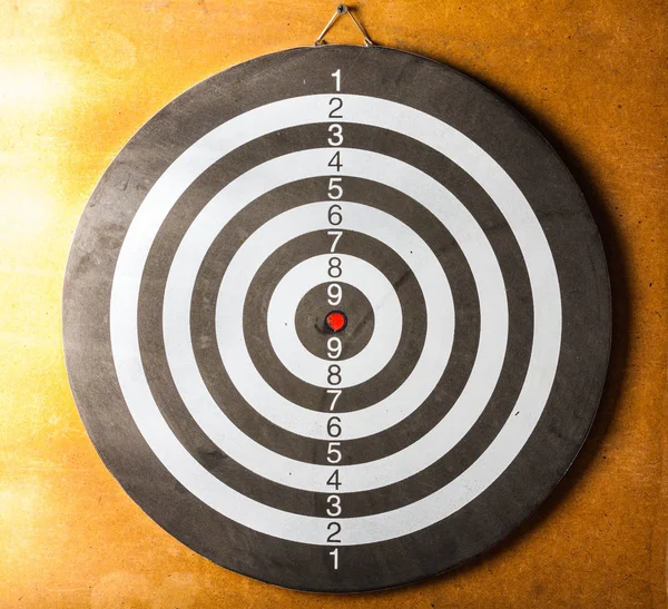 Vintage dart board on dark wall — Stock Photo, Image