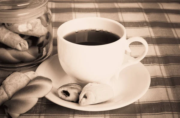 Taze lezzetli kurabiyeler ve masa örtüsü üzerinde sıcak çay — Stok fotoğraf