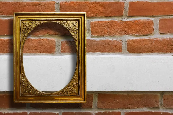 Marco de madera dorada para imágenes en la pared de ladrillo viejo — Foto de Stock