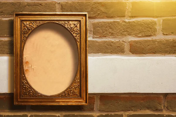 Marco de madera dorada para imágenes en la pared de ladrillo viejo — Foto de Stock