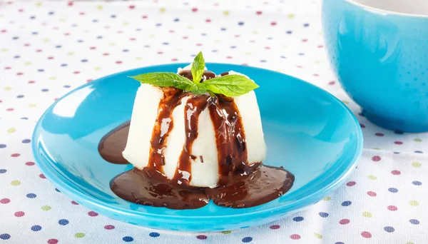 Cream pudding with chocolate sauce and mint on  multicolored tab — Stock Photo, Image