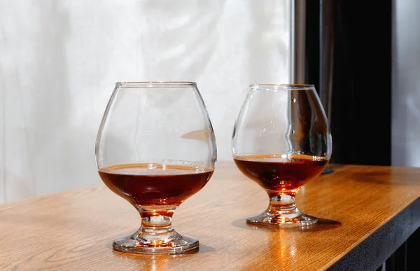 Two goblets of brandy on wooden old counter top — Stock Photo, Image