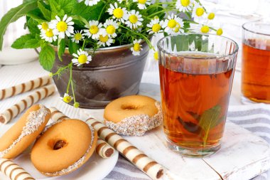 One cups of hot tea with delicious cookies on  wooden table.