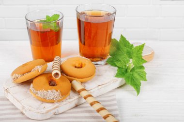 Ahşap masada lezzetli kurabiye ile sıcak çay iki bardak.