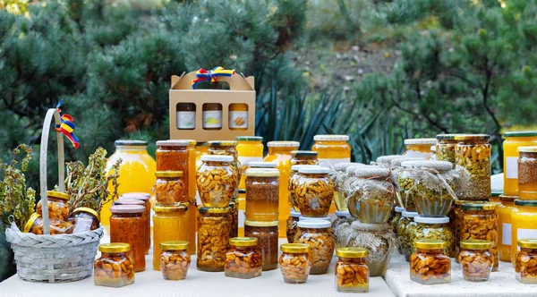 Surtido de tarros de miel en el puesto de mercado. Venta de miel natural en feria al aire libre . — Foto de Stock