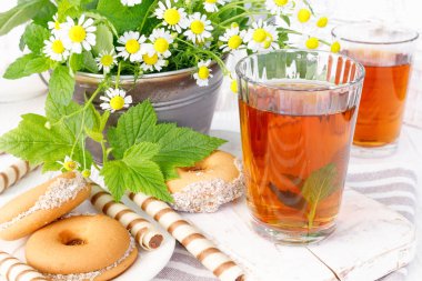 Beyaz ahşap masada lezzetli kurabiyelerle iki fincan sıcak çay..