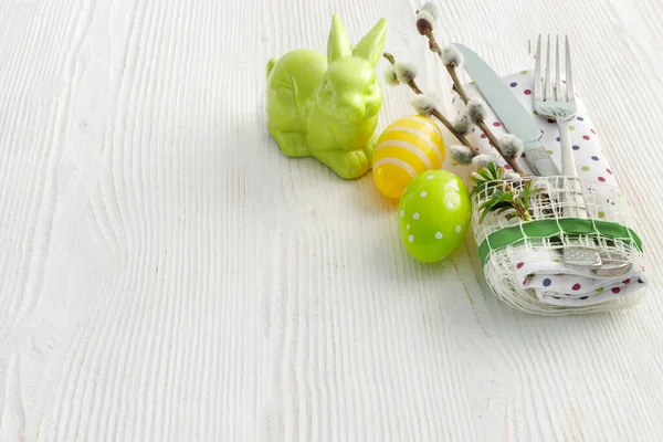 白色木制桌子上的黄色和绿色彩蛋是复活节的象征 — 图库照片