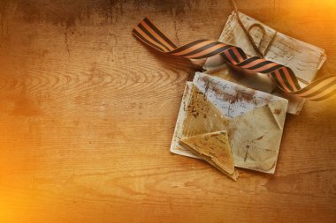 Zafer Günü - 9 Mayıs 1945. St. George Ribbon, ön cepheden gelen mektuplar albüm fotoğrafları ve İkinci Dünya Savaşı 'nın kartpostalları eski ahşap masada. Metnin için kopyalama alanı olan düz bir üst görünüm oluştur.